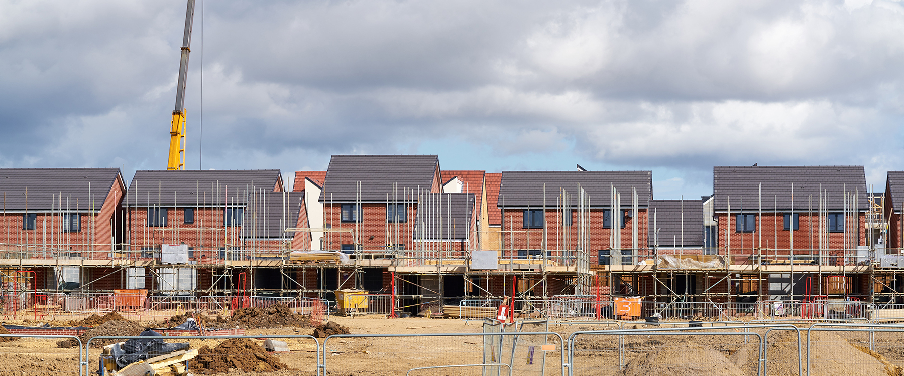 Construction site with houses in the background)