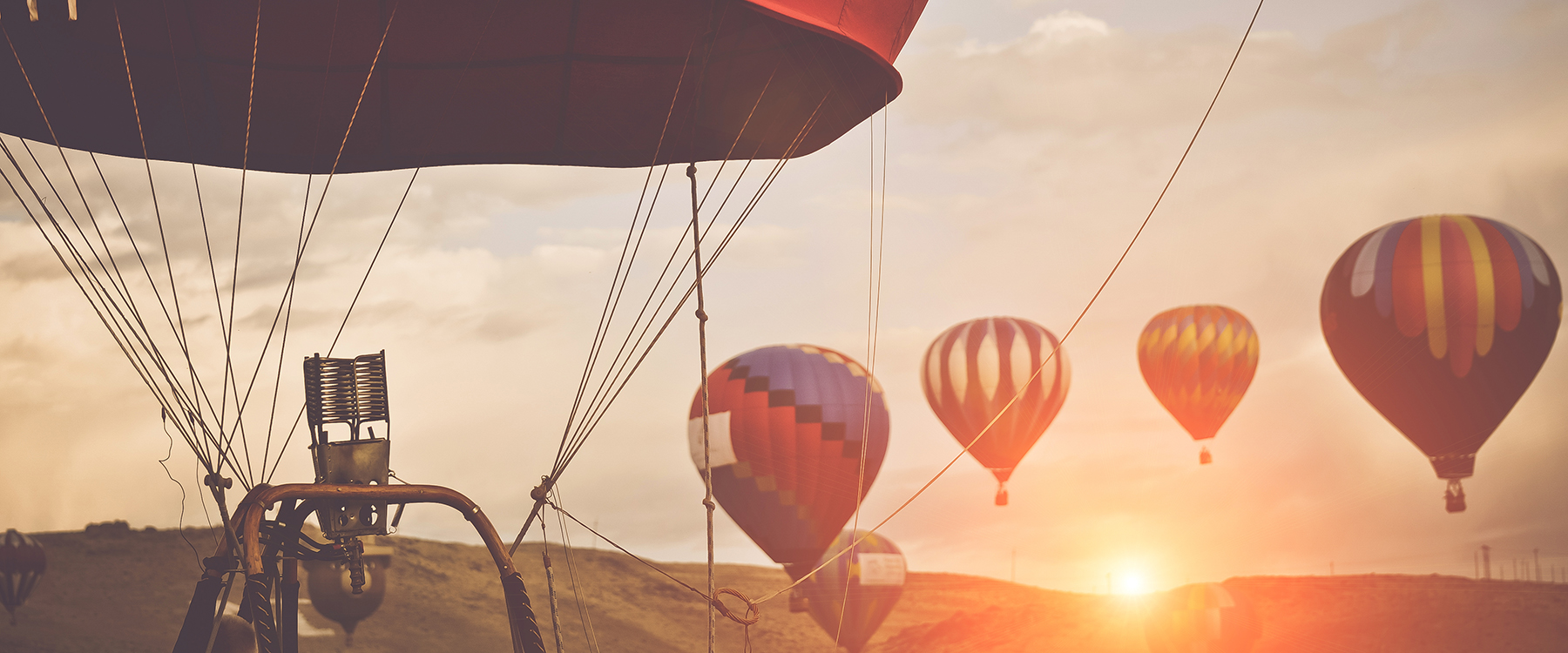 Hot air balloons floating in the sunset)