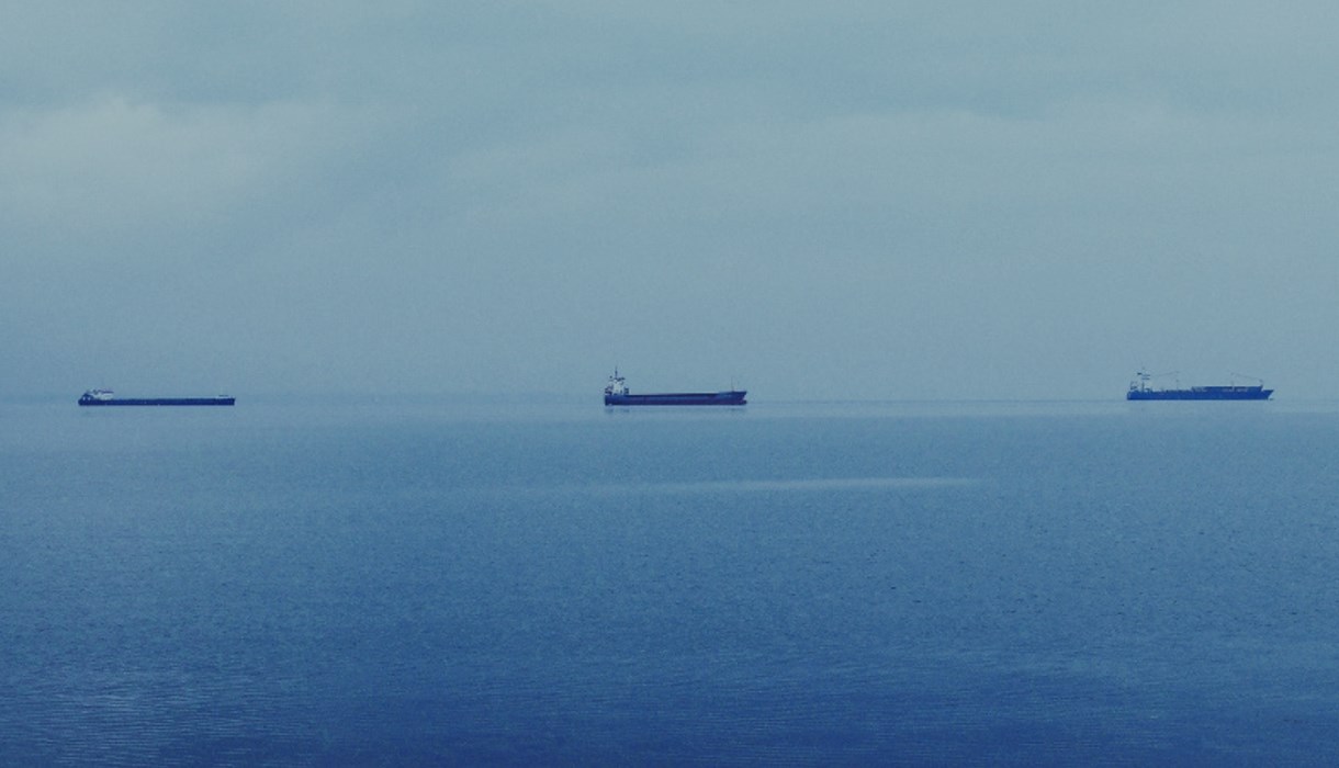 Three cargo ships on the sea in the distance